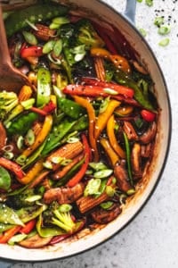 overhead view of half of a skillet full of cooked veggies in asian stir fry sauce
